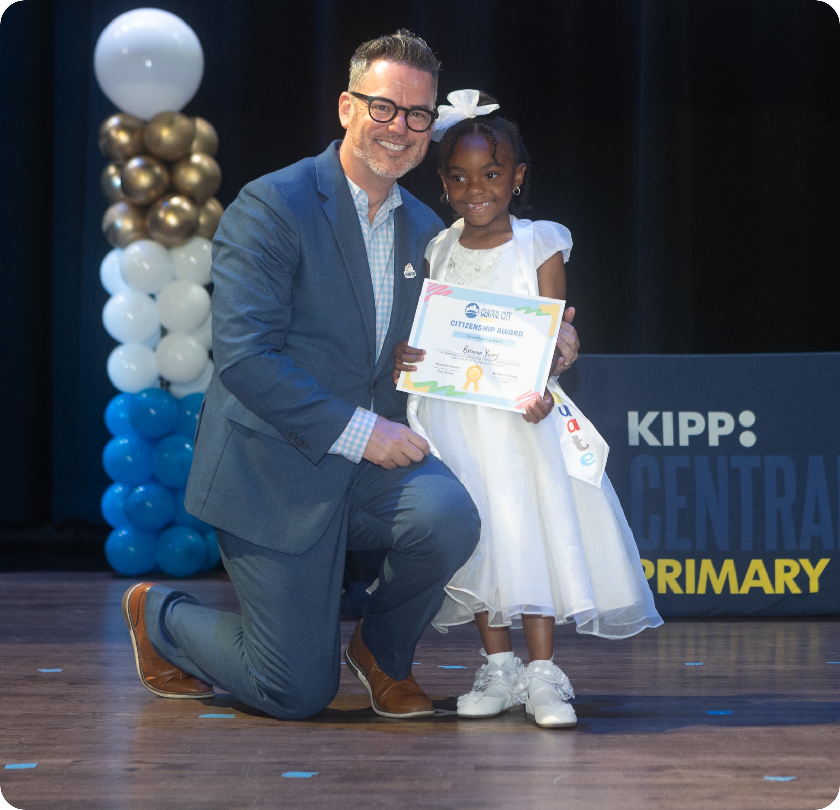 teacher poses with proud student