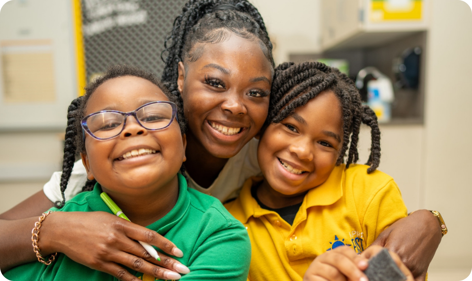 teacher smiles with two students