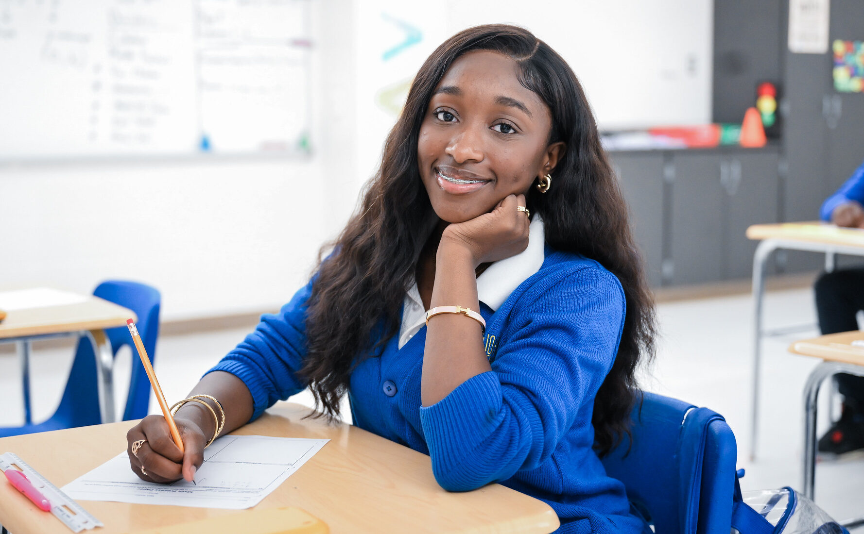 John F. Kennedy High School student smiling at her desk